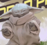 a close up of a baby yoda statue with his eyes closed .