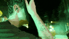 a man with a tattoo on his arm is wearing a pair of ear buds