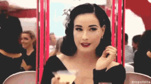 a woman in a black dress is holding a glass of champagne in her hand ..