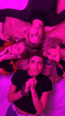 a group of girls are laying in a circle with purple lights