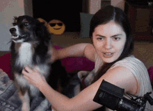 a woman petting a dog in front of a microphone that says ' nikon ' on it