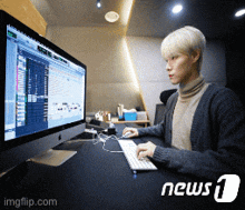a man is typing on a keyboard in front of a computer screen which says news 1