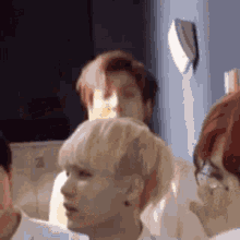 a group of people are standing in a room and one of them is looking at the camera .