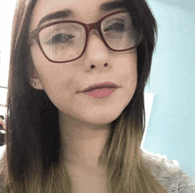 a woman wearing glasses looks at the camera
