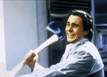 a man is smiling while holding a large axe in his hand .