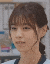 a close up of a woman 's face with a blue shirt on
