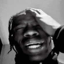 a black and white photo of a person touching a man 's forehead .