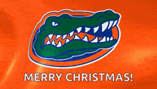 the florida gators logo is on an orange background with the words merry christmas .