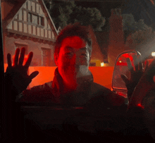 a man in a car waving his hand in front of a building