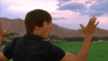 a man in a black shirt is standing on a golf course