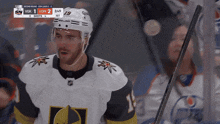 a hockey player with the number 19 on his helmet stands in front of a scoreboard