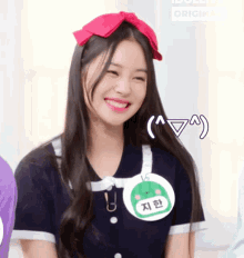 a girl wearing a name tag with the number 16 on it smiles