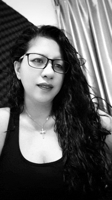 a woman wearing glasses and a necklace with a cross on it