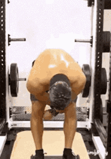 a man is doing a workout in a gym with a barbell .