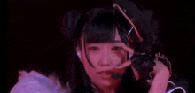 a close up of a woman 's face with a microphone in her hand in a dark room .