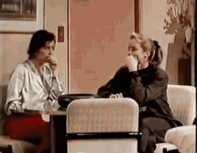 a man and a woman are sitting at a table and talking to each other .