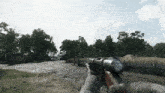 a person holding a gun in a video game with a fence in the background
