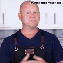 a man wearing a blue shirt and an apron is making a funny face