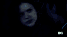 a close up of a man 's face in the dark with a blue background .