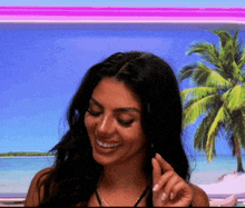 a woman is smiling in front of a palm tree