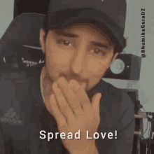 a man wearing a hat is covering his mouth with his hands and the words `` spread love '' are written below him .