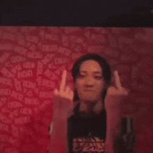 a man is making a funny face while giving the middle finger .