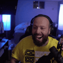 a man with a beard wearing headphones and a yellow shirt that says bb on it
