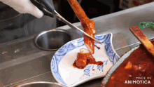 a person is cutting a piece of meat on a plate that says made in animotica on the bottom