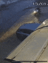 a car is driving through a flooded street on a rainy day .