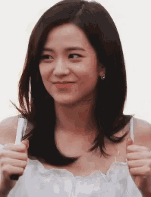 a woman in a white tank top is giving a thumbs up sign