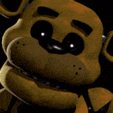 a close up of a yellow teddy bear with black eyes and a black nose .