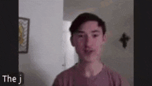 a young man is talking on a video call while wearing a pink t-shirt .