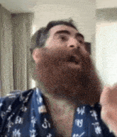 a man with a beard is wearing a blue shirt with chinese characters on it