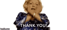 a woman in a blue dress is giving a thank you gesture .