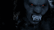 a close up of a werewolf with red eyes and teeth