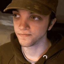 a man wearing a hat and a hoodie with the letter c on the collar