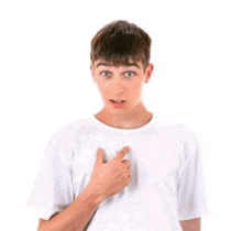 a young boy in a white t-shirt is pointing at his chest