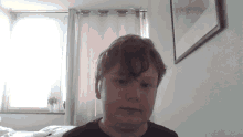 a young boy looks at the camera in a bedroom
