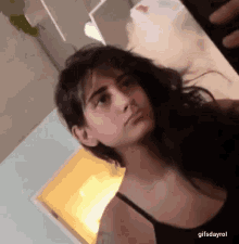 a woman with a nose ring is taking a picture of herself in a mirror .