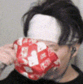 a pixelated image of a person holding a red and white item with a heart on it