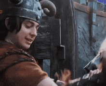 a man wearing a helmet with horns is smiling and talking to another man