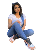 a woman with blue hair is sitting on the ground wearing a pair of air jordan shoes