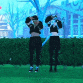 a couple of girls are standing next to each other in a park wearing virtual reality headsets .