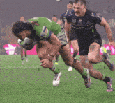 a rugby player wearing a green jersey with the number 15 on it