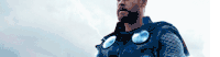 a man in a superhero costume is standing in front of a lightning bolt .