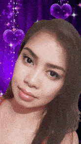 a close up of a woman 's face with purple hearts behind her