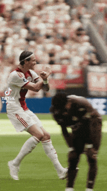 a soccer player is jumping in the air while another player watches