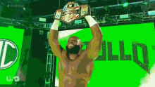 a man is holding up a wrestling championship belt