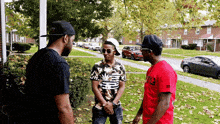 a man wearing a red shirt with the number 92 on it talks with two other men