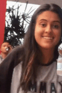 a woman wearing a shirt with the word mad on it smiles